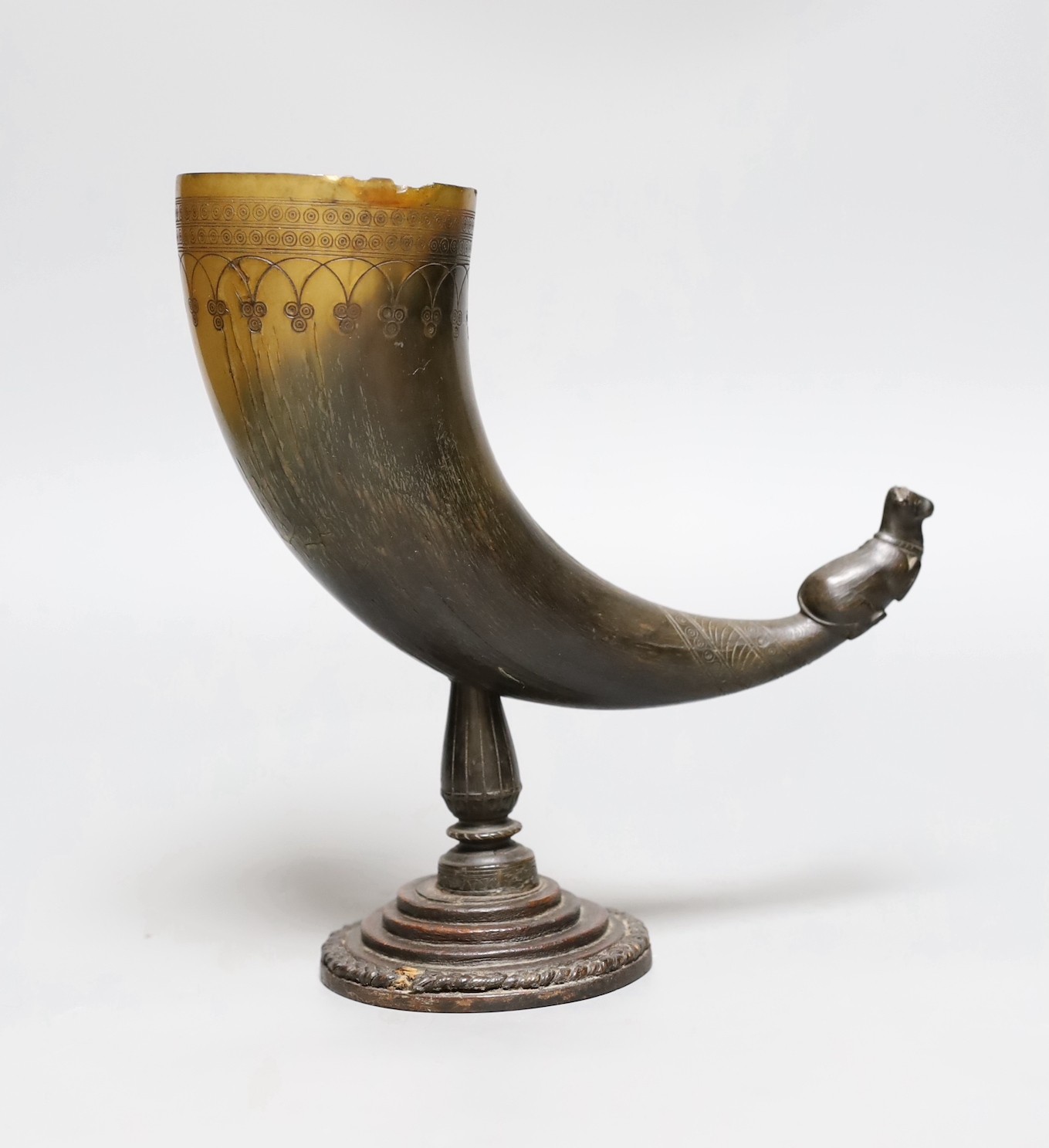 A Persian horn rhyton, 19th century or earlier, with horn stem and stepped wood base, 21cms high, 20.5cm long